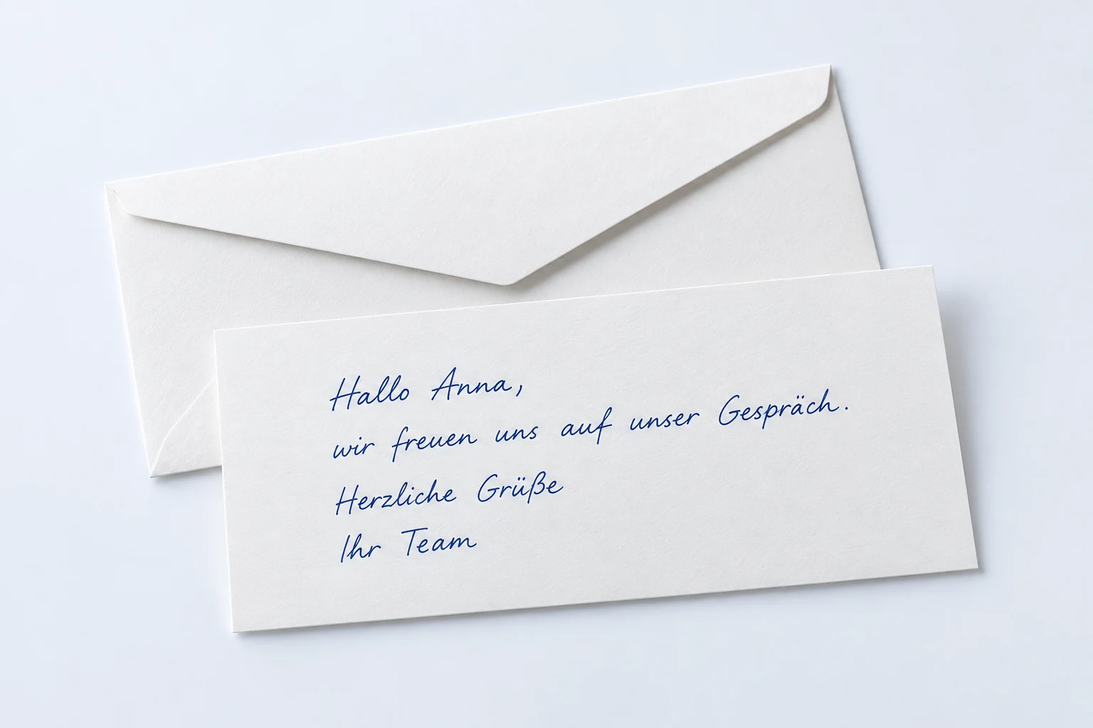 Handgeschriebene DIN-lang-Karte mit geöffnetem länglichem Briefumschlag.