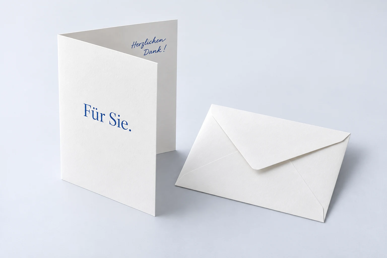 Geöffnete A6-Klappkarte im Hochformat mit blauem Titel und handschriftlichem Dank im Inneren.